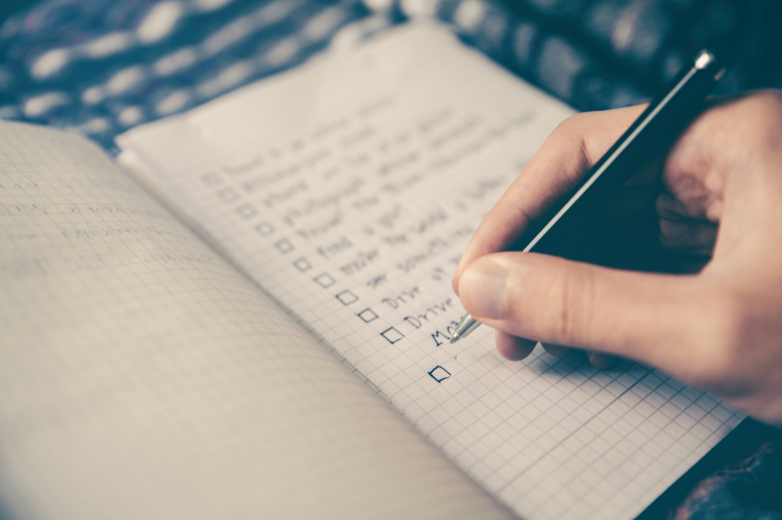 A messy calendar filled with crossed-out tasks next to a phone displaying social media