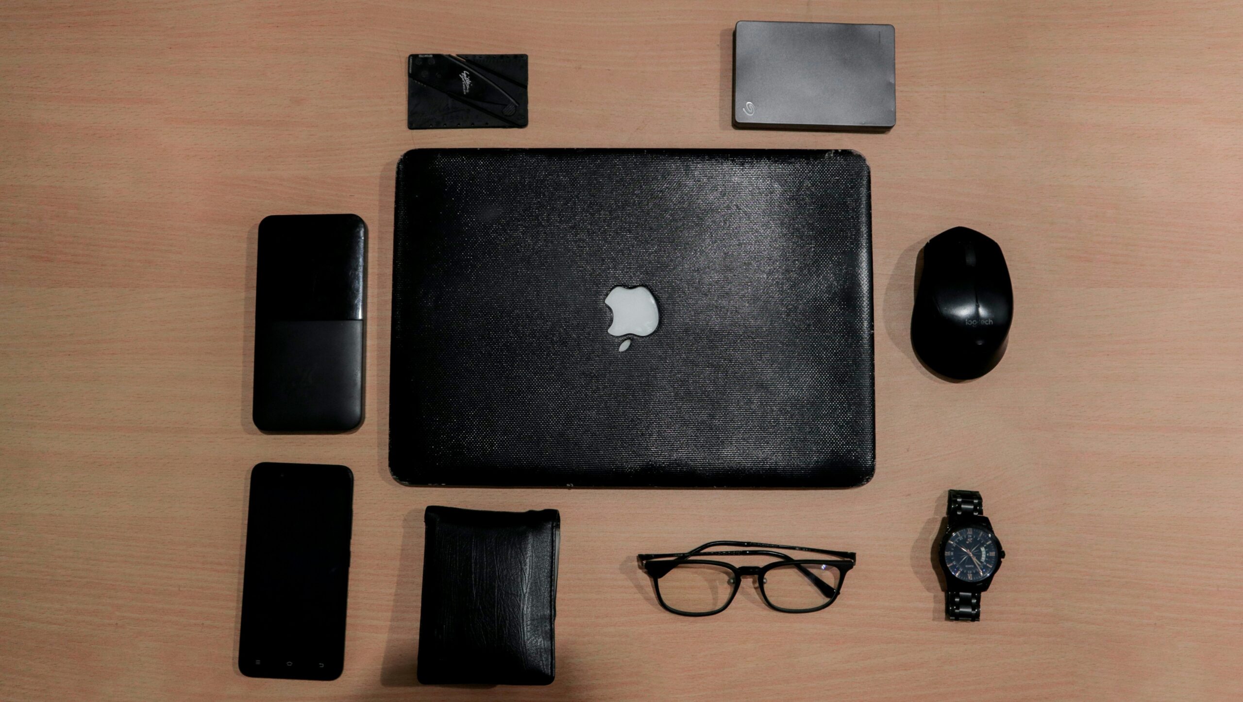 A messy desk covered in colorful sticky notes compared to a sleek smartphone displaying an organized task list.
